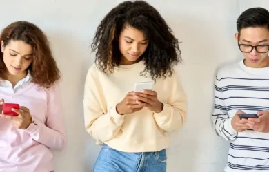 Three teens use their devices.