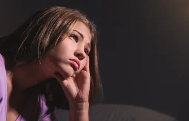 A young girl looks into the distance, upset.